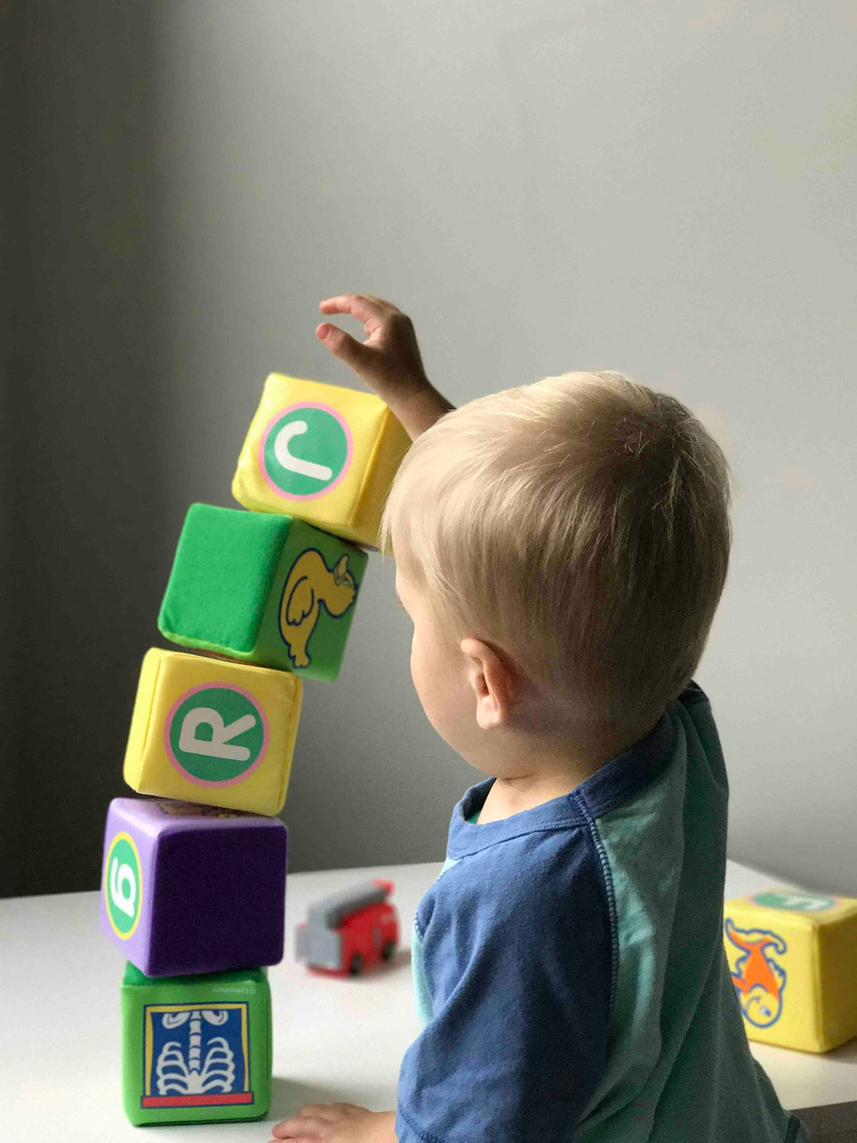 Enfant qui joue avec des cubes sur une table en bois