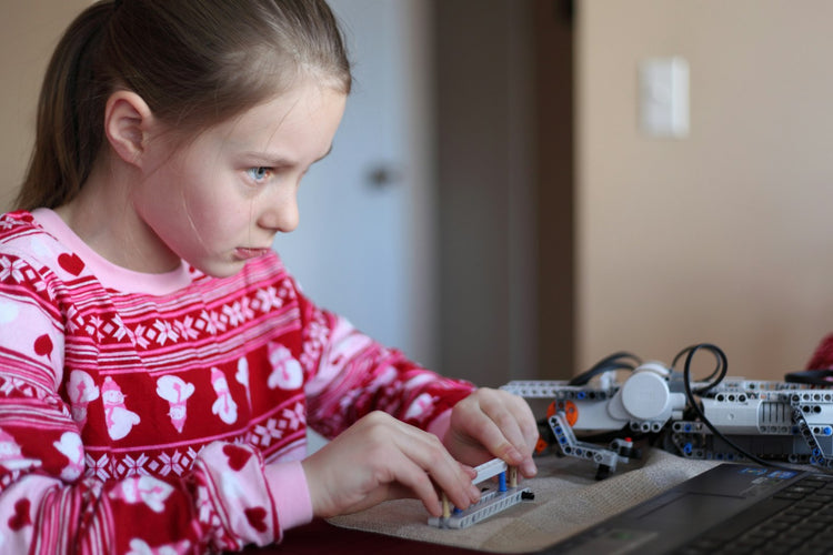 Enfant concentré en train d'assembler un jouet de construction