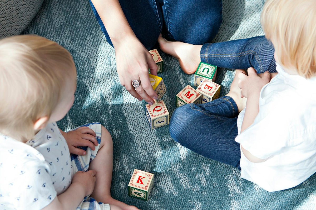 Deux tout-petits qui jouent avec des cubes lettres
