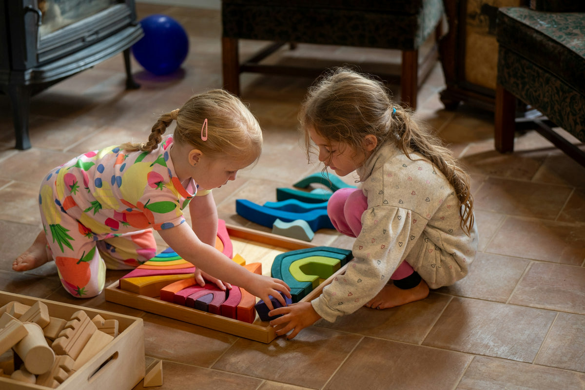 Deux petites filles qui jouent avec des cubes en bois colorés